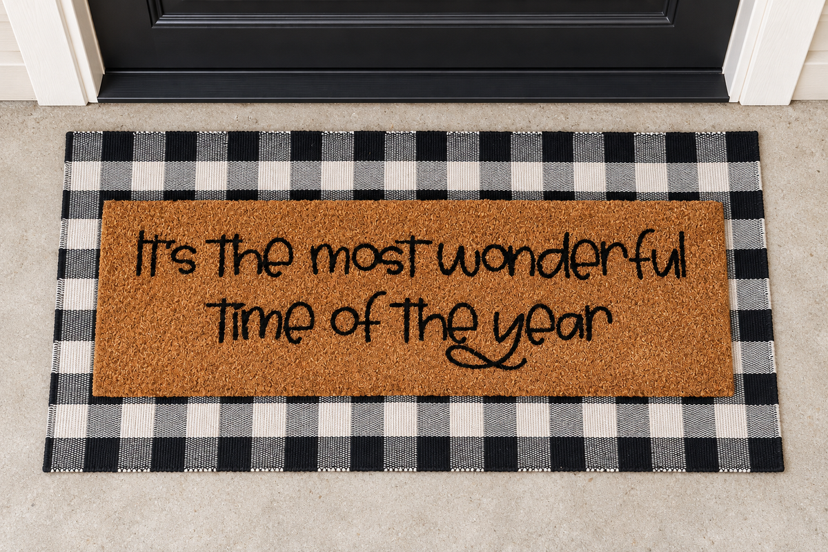 XL Doormat | It's the Most Wonderful Time of the Year layered over a black and ivory buffalo plaid runner at a black door.