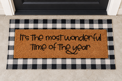 XL Doormat | It's the Most Wonderful Time of the Year layered over a black and ivory buffalo plaid runner at a black door.