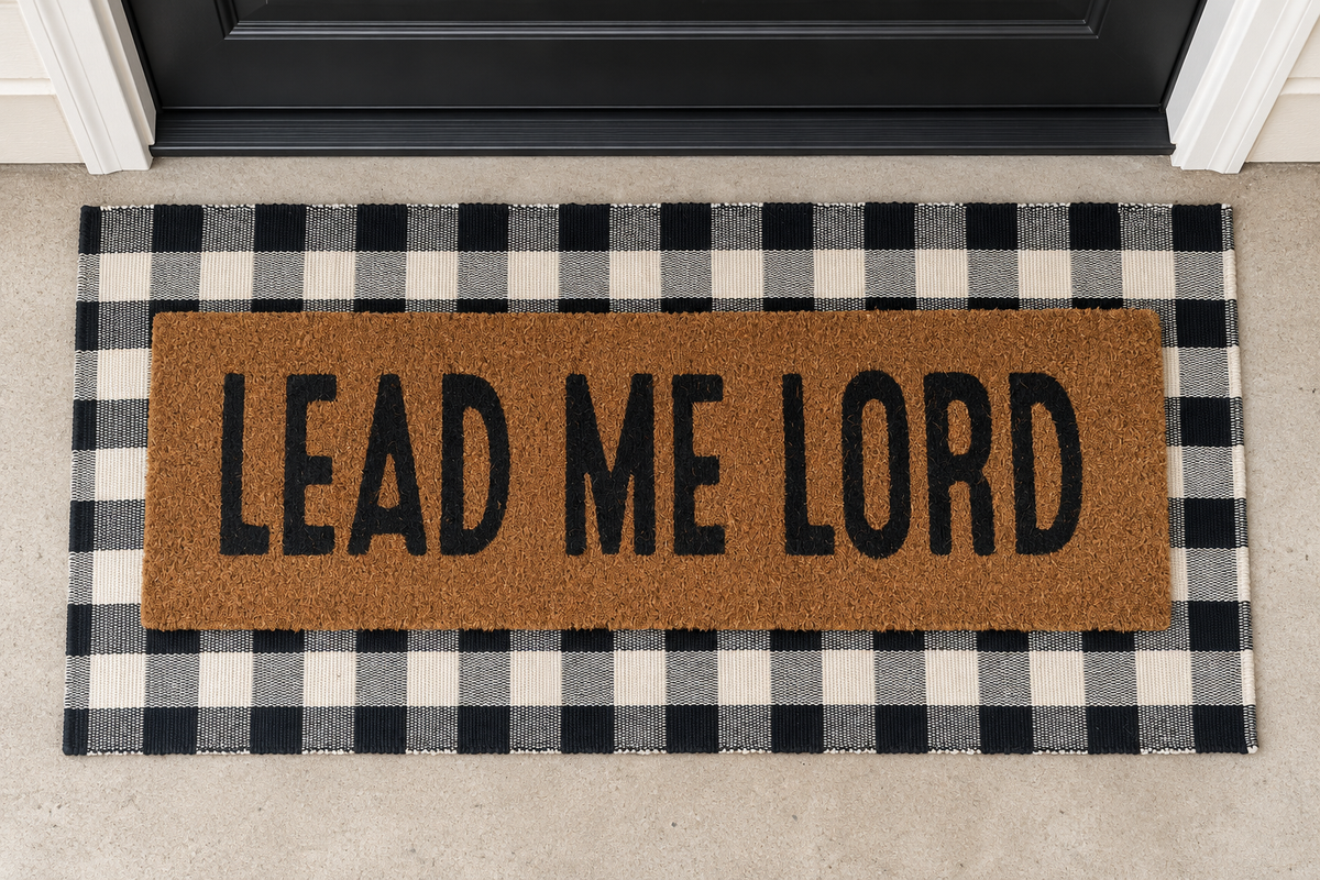 XL Christian Doormat | Lead Me Lord layered over a black and ivory buffalo plaid runner at a black door.