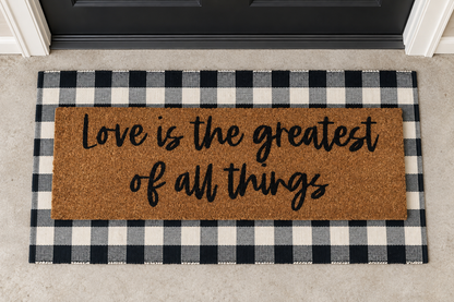 XL Doormat | Love Is the Greatest of All Things layered over a black and ivory buffalo plaid runner at a black door.