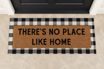 XL Doormat | There's No Place Like Home layered over a black and ivory buffalo plaid runner at a black door.