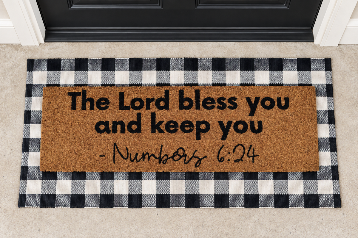 XL Scripture Doormat | Numbers 6:24 layered over a black and ivory buffalo plaid runner at a black door.