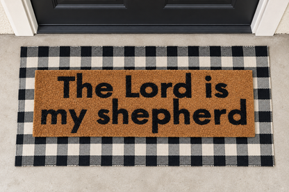XL Scripture Doormat | The Lord Is My Shepherd layered over a black and ivory buffalo plaid runner at a black door.