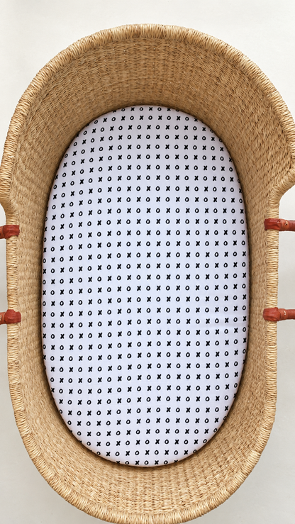 XO organic cotton muslin bassinet and small changing pad sheet shown in a woven basket. Sheet only; basket and pad not included.