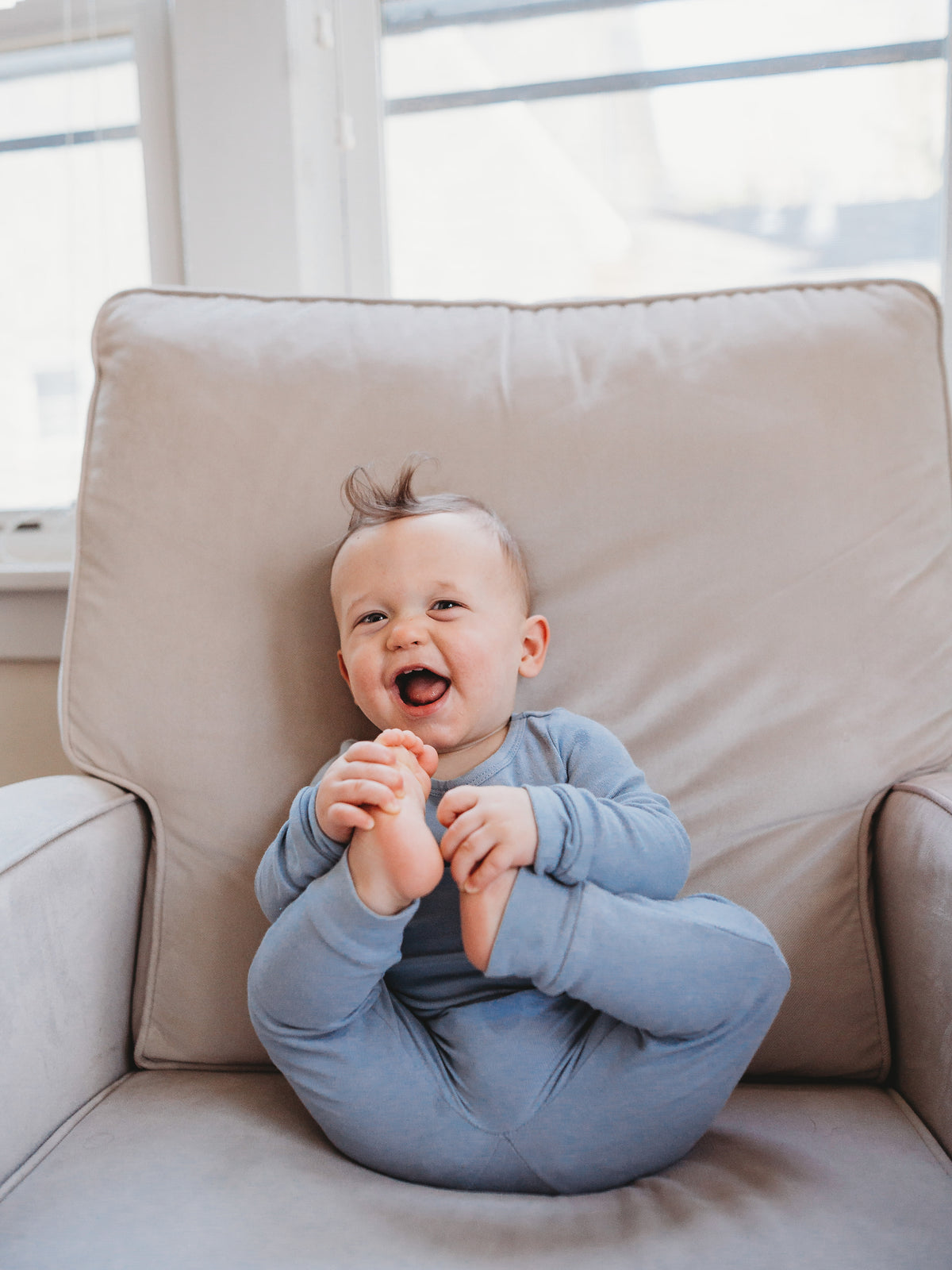 Organic Baby + Kids Pajama Set | Tradewinds — Baby wearing the set on an armchair