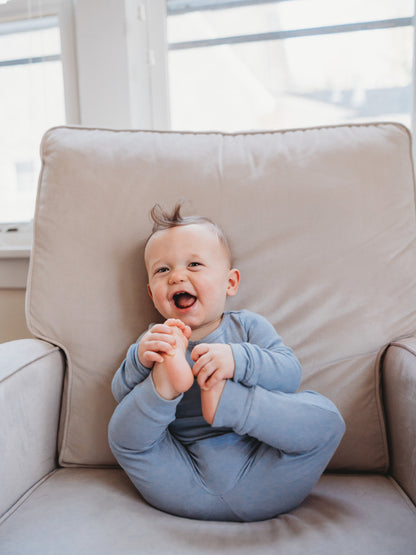 Organic Baby + Kids Pajama Set | Tradewinds — Baby wearing the set on an armchair
