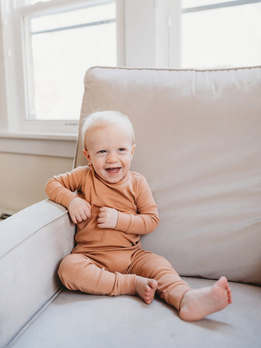 Baby wearing ginger pajamas seated in an armchair