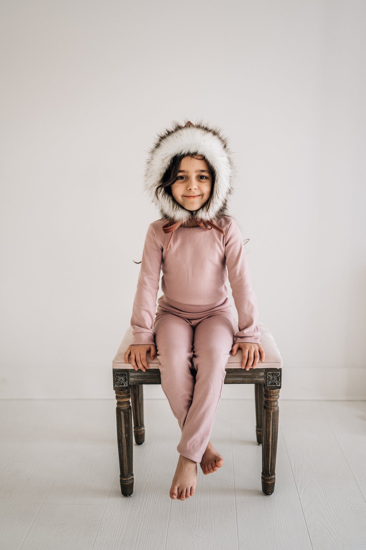 Organic Baby + Kids Pajama Set | Mauve — Child wearing the set seated on a stool