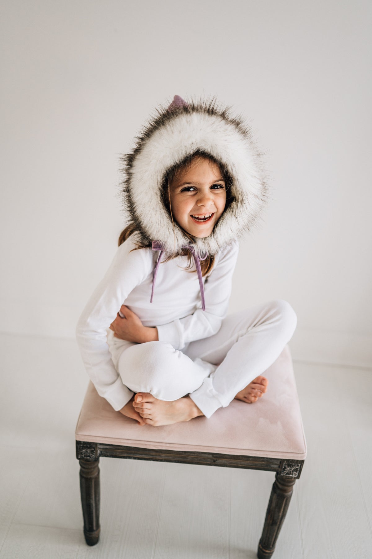 Organic Baby + Kids Pajama Set | White — Child wearing white pajamas seated on a stool