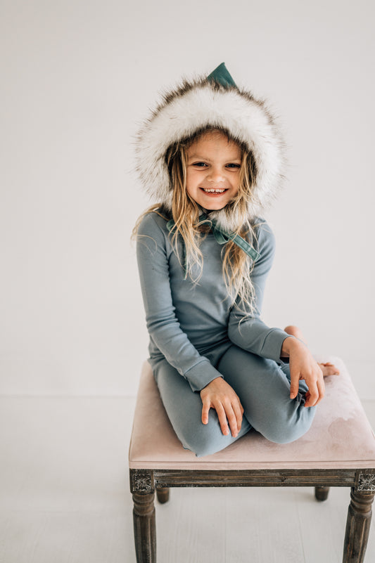 Child wearing Tradewinds pajamas seated on a stool