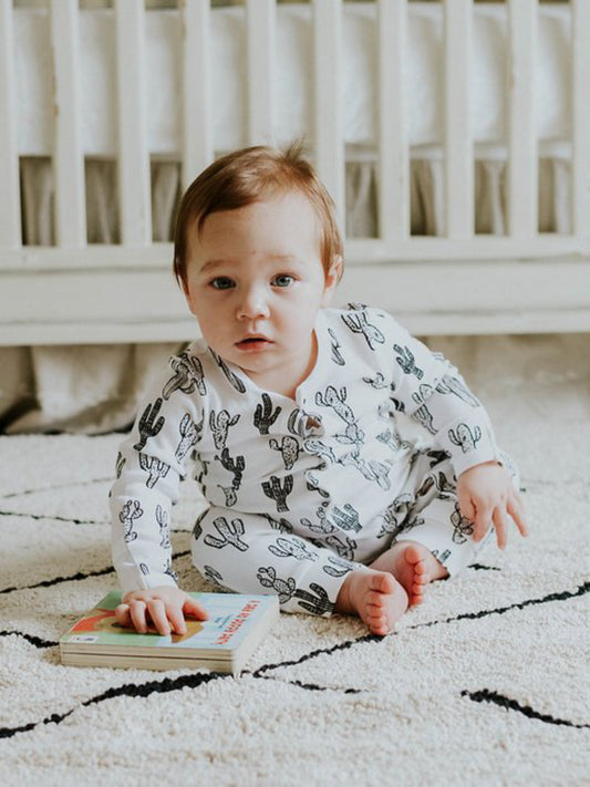 Baby sitting and playing in the B+W Cactus organic button coverall.