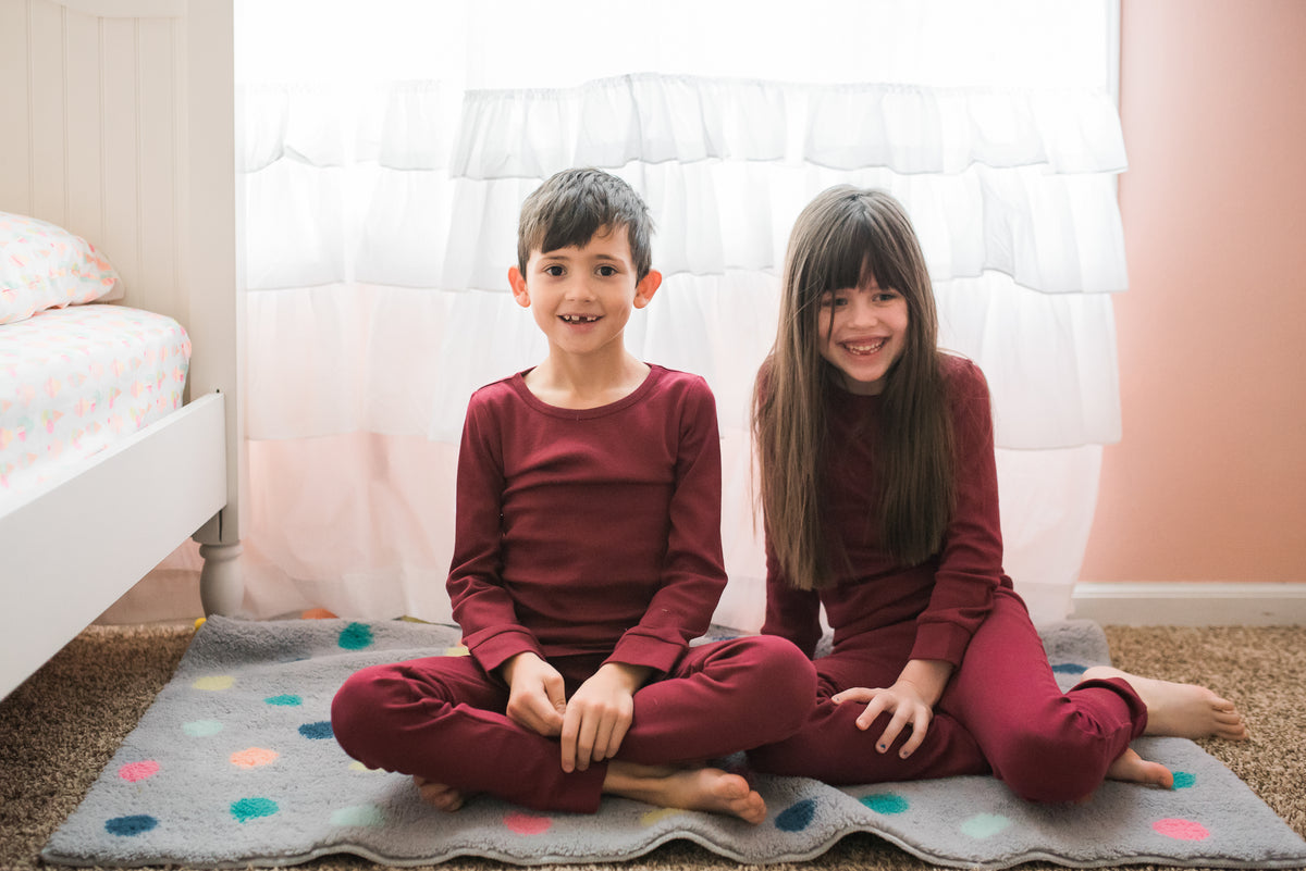 Organic Baby + Kids Pajama Set | Maroon — Two children wearing matching maroon pajamas