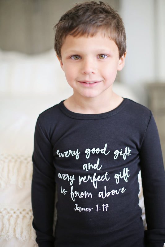 Child wearing a black James 1:17 pajama top