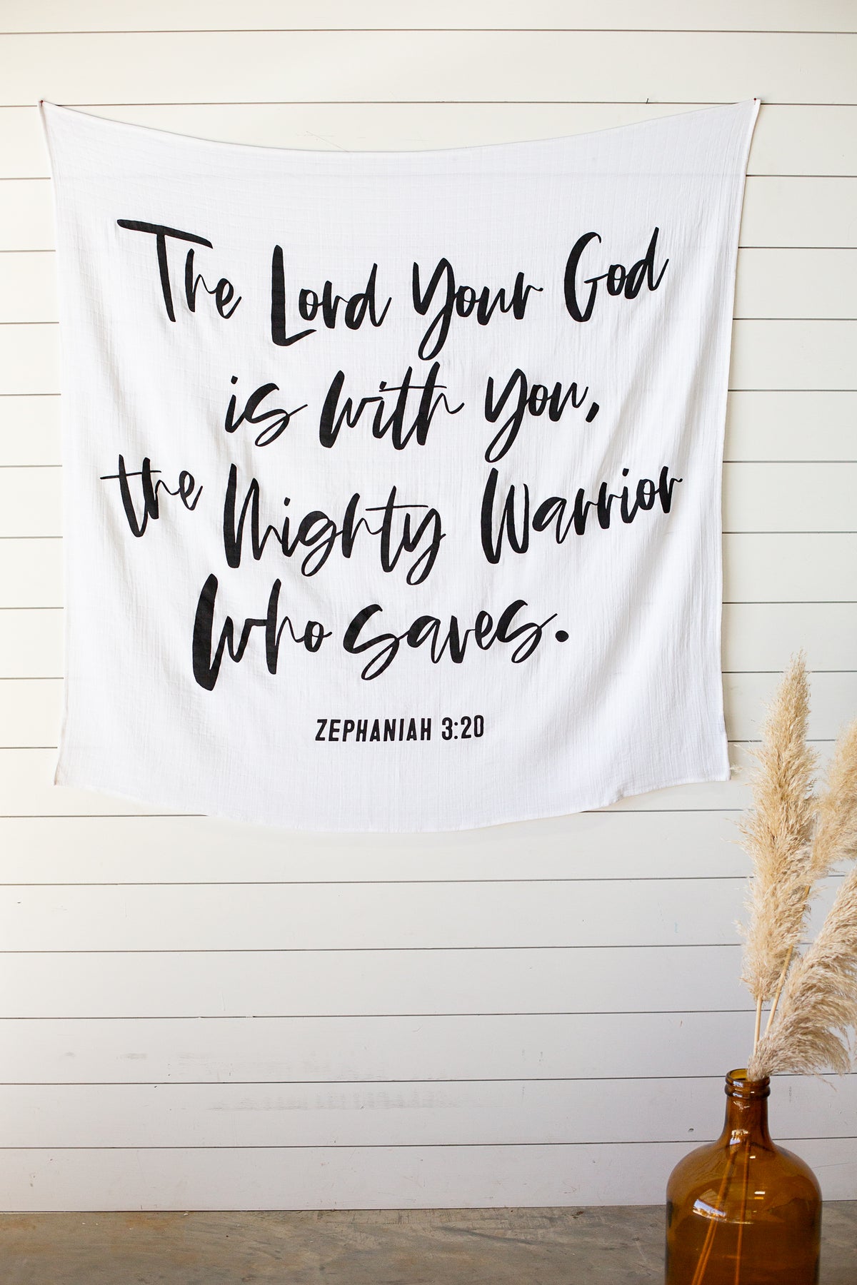Zephaniah 3:17 Scripture swaddle displayed as nursery wall art by Modern Burlap