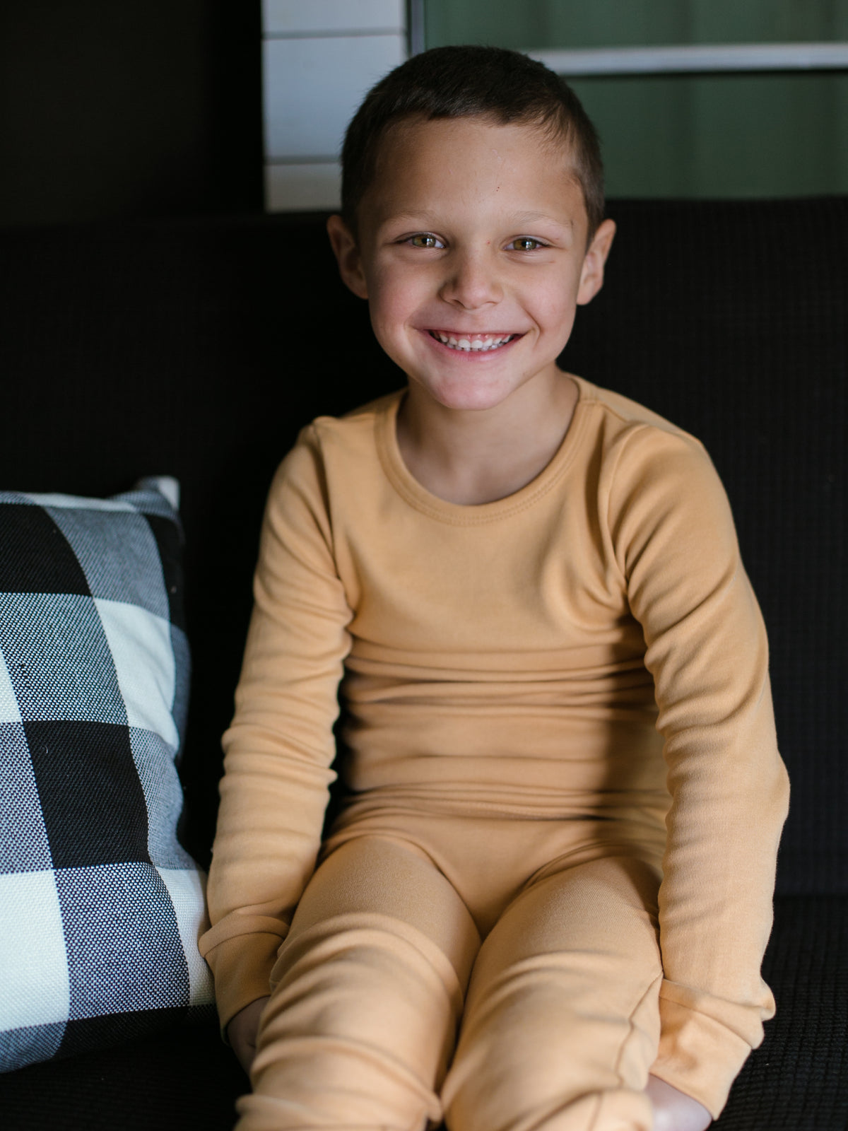 Organic Baby + Kids Pajama Set | Honey — Child seated in honey pajamas