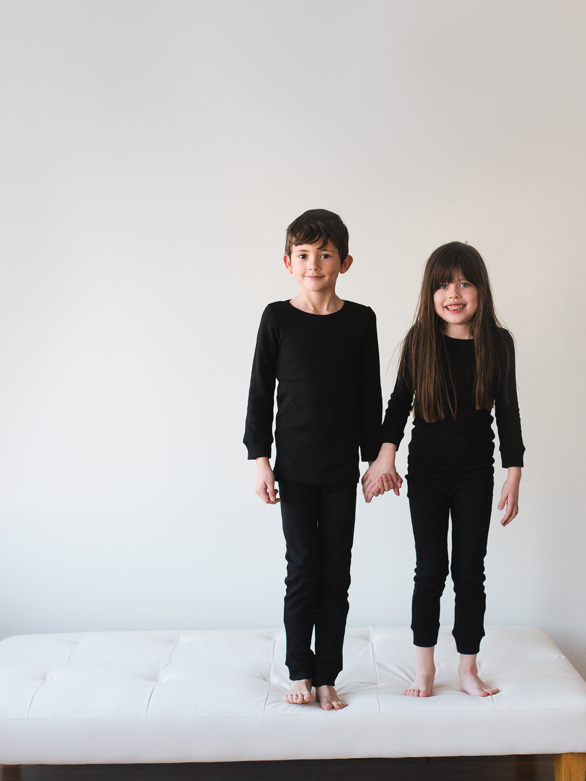 Organic Thermal Baby + Kids Pajama Set | Black — Full-length front view of children in black pajamas