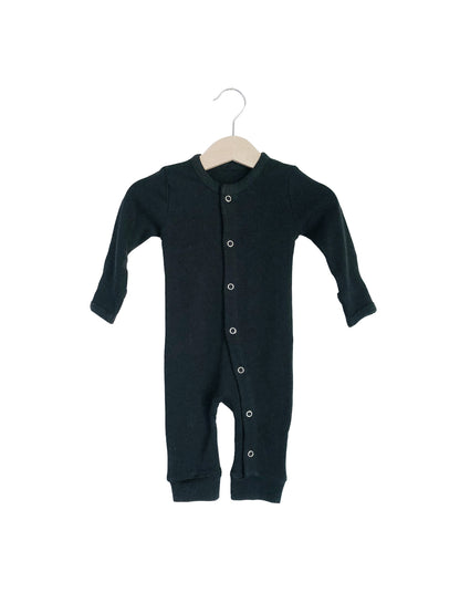 Black button coverall on a hanger, showing the front closure and ankle cuffs