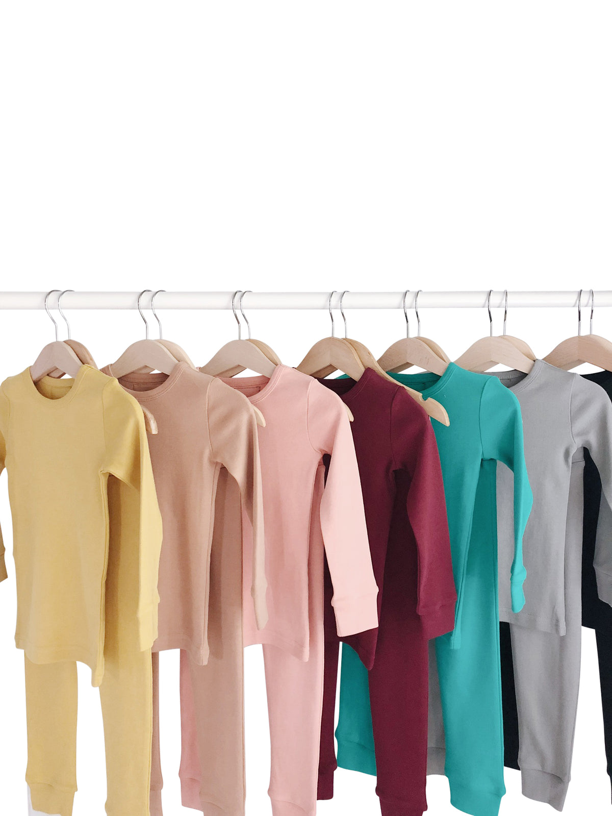 Organic Baby + Kids Pajama Set | Solid Colors — Solid-color pajama sets arranged on hangers