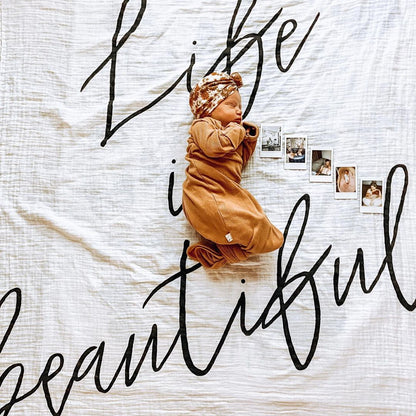 Baby or child pictured with Life Is Beautiful Organic Swaddle.