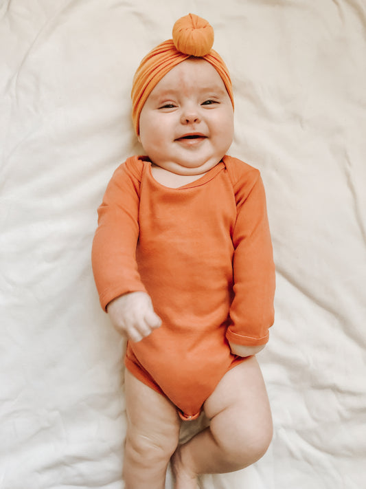 Solid color organic long sleeve baby bodysuit by Modern Burlap