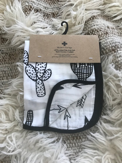 Folded Cactus + Arrows reversible burp cloth in kraft product packaging.