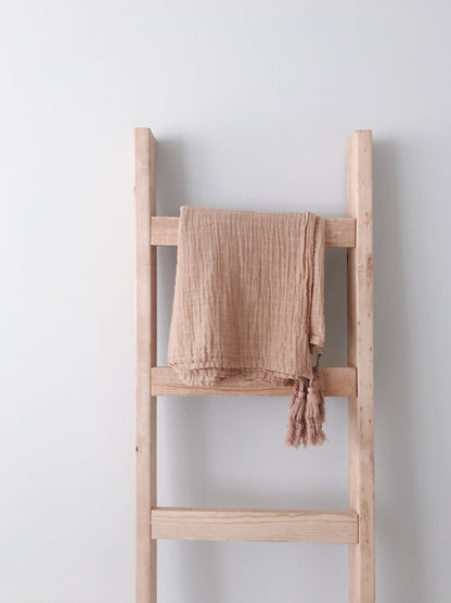 Ginger tassel muslin throw draped over a wooden blanket ladder
