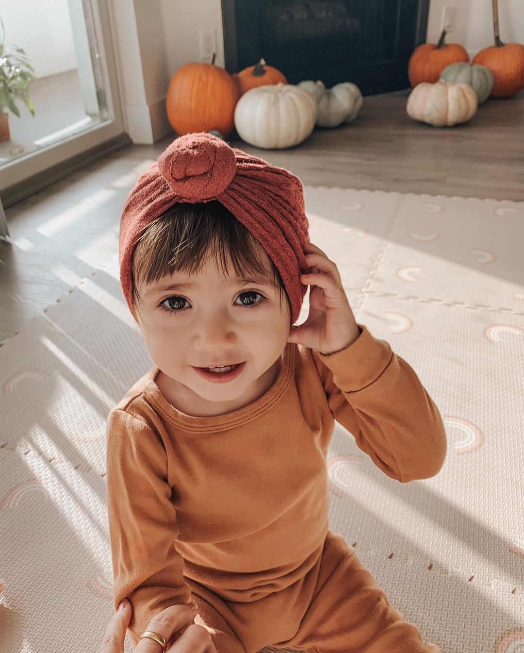 Organic Baby + Kids Pajama Set | Ginger — Child wearing the set beside pumpkins