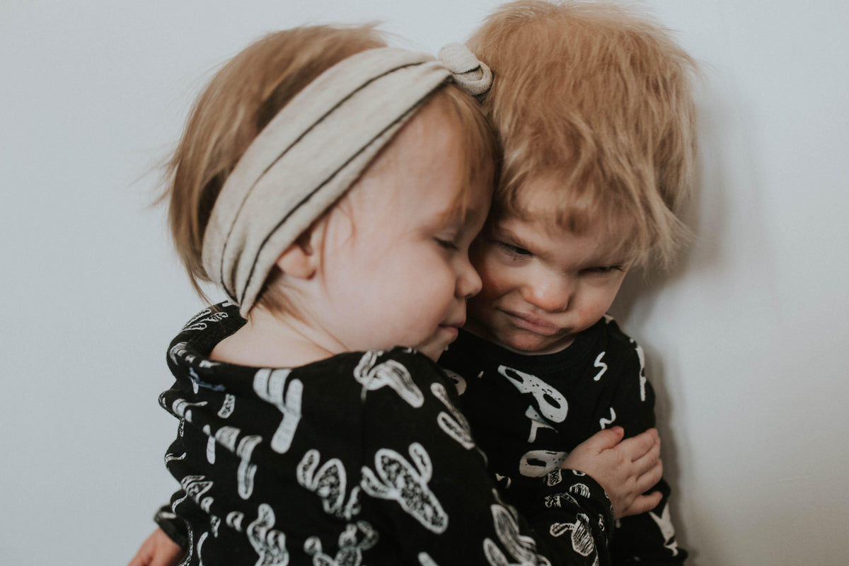 Organic Baby + Kids Pajama Set | White on Black Cactus — Close-up of children wearing coordinating prints
