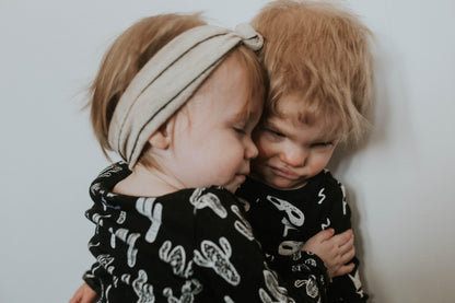 Organic Baby + Kids Pajama Set | White on Black Cactus — Close-up of children wearing coordinating prints